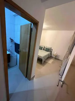 a bathroom with a glass door leading to a living room at Appartement cosy et spacieux in Praia