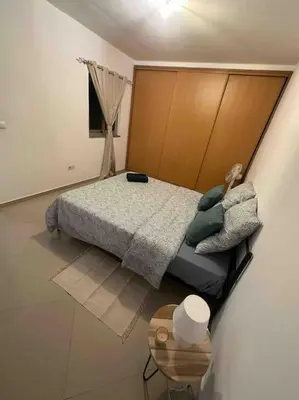 a bedroom with a bed and a table in it at Appartement cosy et spacieux in Praia