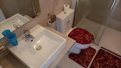 a bathroom with a sink and a toilet and a mirror at T2 da Marília fonte francês in Mindelo