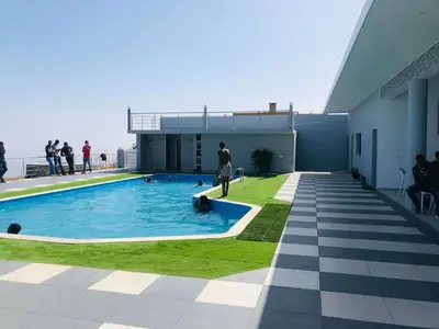 a man standing next to a swimming pool on a building at COSEC Tours in Cova Figueira