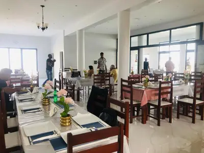 a dining room with tables and people standing in the background at COSEC Tours in Cova Figueira