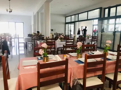 a dining room with tables and chairs with flowers on them at COSEC Tours in Cova Figueira