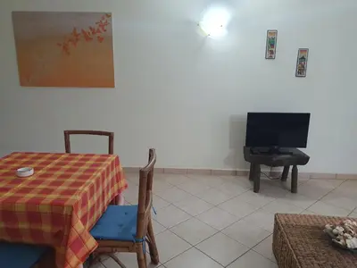 a living room with a table and a television at Holiday Properties Leme Bedje in Santa Maria