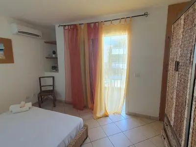a bedroom with a bed and a window with curtains at Holiday Properties Leme Bedje in Santa Maria