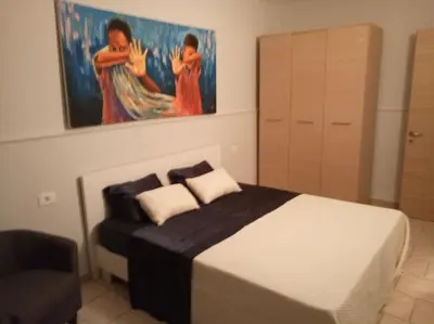 a bedroom with a bed with a painting on the wall at Apartamento Djadsal Moradias L01 próximo à praia in Santa Maria
