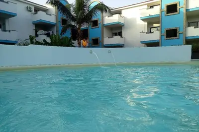 a swimming pool in front of some buildings at Apartamento Djadsal Moradias L01 próximo à praia in Santa Maria