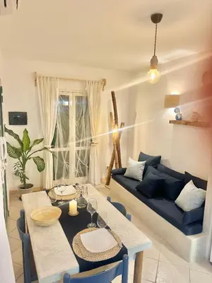 a living room with a table and a blue couch at Boutique Apartments Ibiscus in Santa Maria