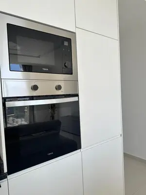 a microwave oven sitting inside of a white cabinet at Sharksproperties Apartment in Mindelo