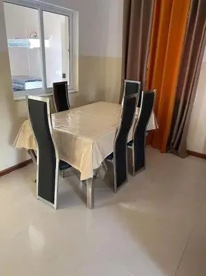 a dining room table and chairs with a table and a window at Jbct & SOLANGE APART in Praia