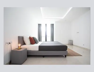 a bed in a white room with a bed sidx sidx sidx at Filomena Apartments ORIENTAL in Mindelo