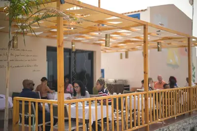 a group of people sitting at a table in a restaurant at Encosta Azul in Cidade Velha