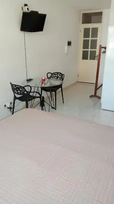 a room with a table and two chairs and a door at Estúdio Vieira in Praia