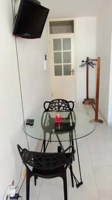 a glass table and a chair in a room at Estúdio Vieira in Praia