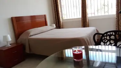 a bedroom with a bed and a glass table with a candle at Estúdio Vieira in Praia