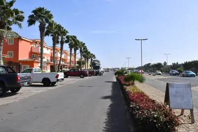 a street with cars parked on the side of the road at Kyaala Djadsal Moradias pool&sea in Santa Maria