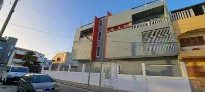 a building on a street with cars parked next to it at Apartamento T1 Mobilado Espargos/Sal in Espargos