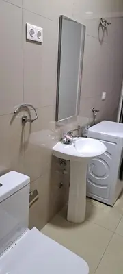 a bathroom with a sink and a toilet and a mirror at Apartamento T1 Mobilado Espargos/Sal in Espargos