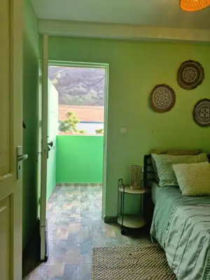 a bedroom with green walls and a bed and a window at Casa Medina in Fajãzinha
