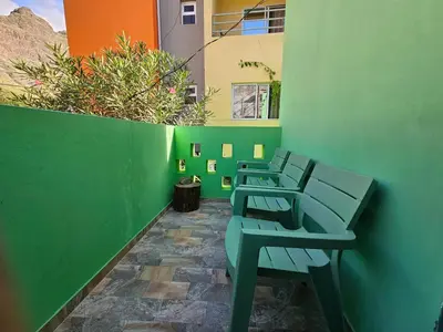 a row of benches sitting next to a green wall at Casa Medina in Fajãzinha