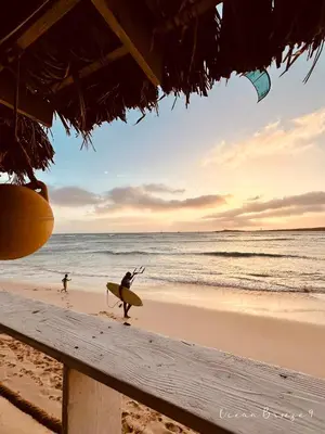 a person walking on the beach with a surfboard at Ocean Breeze 9 in Sal Rei
