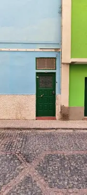 a green door on the side of a building at Casas do Cinema II in Mindelo