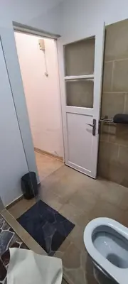 a bathroom with a white door and a toilet at Casas do Cinema II in Mindelo