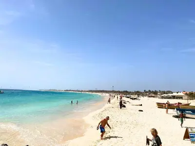 a group of people on a beach with the ocean at Atlantic SAL - One Bedroom Apt in Santa Maria