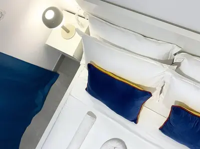 a bed with blue and white pillows on a boat at Atlantic SAL - One Bedroom Apt in Santa Maria