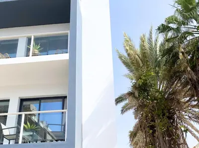 a palm tree in front of a building at Atlantic SAL - One Bedroom Apt in Santa Maria