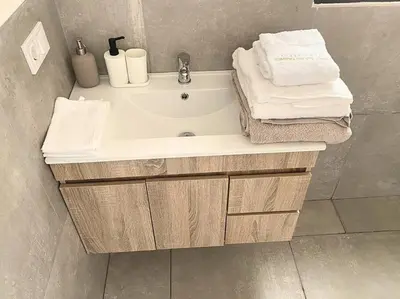 a bathroom with a tub and a sink and towels at Atlantic SAL - One Bedroom Apt in Santa Maria