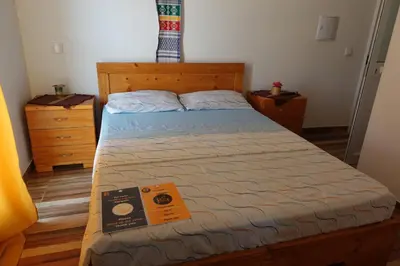a bedroom with a bed with a book on it at Residencial Ribeira Torta in Porto Novo