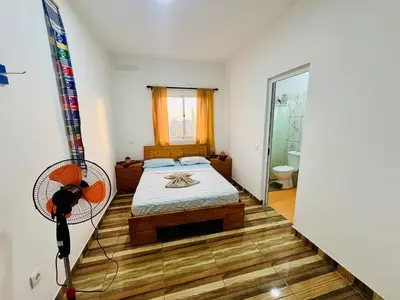 a bedroom with a bed and a fan on the wall at Residencial Ribeira Torta in Porto Novo