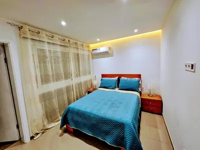 a bedroom with a blue bed and a window at ACG Plato Vacation Apartment with Balcony in Praia