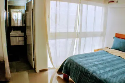 a bedroom with a bed and a large window at ACG Plato Vacation Apartment with Balcony in Praia