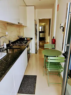 a kitchen with a counter and a table and chairs at ACG Plato Terrace & Balcony Apartments in Praia