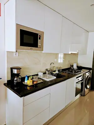 a kitchen with white cabinets and a black counter top at ACG Plato Terrace & Balcony Apartments in Praia