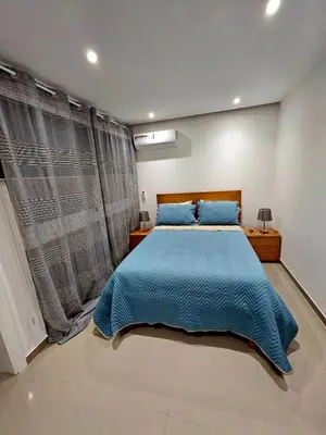a bedroom with a large bed with a blue blanket at ACG Plato Terrace & Balcony Apartments in Praia
