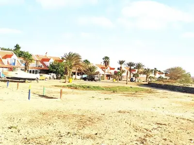 a beach with houses and palm trees in the background at Feeling Cabo Verde in Beirona