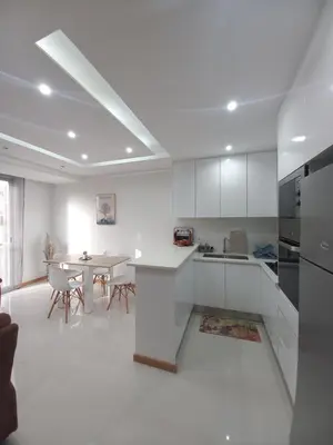 a kitchen with white cabinets and a table in it at SuAparts in Praia