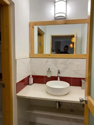 a bathroom with a sink and a mirror at Spencer Residencial QUARTOS in Praia
