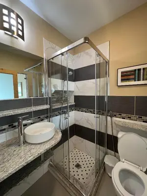 a bathroom with a shower and a toilet and a sink at Spencer Residencial QUARTOS in Praia