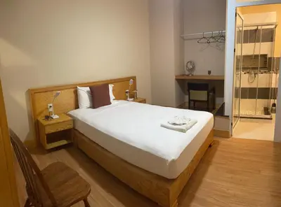 a bedroom with a large white bed and a bathroom at Spencer Residencial QUARTOS in Praia