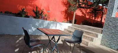 a table and two chairs in front of a wall at Residência Águia in Praia