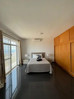 a bedroom with a bed and a large window at Villa RESIDENCIAL EUNICE in Praia