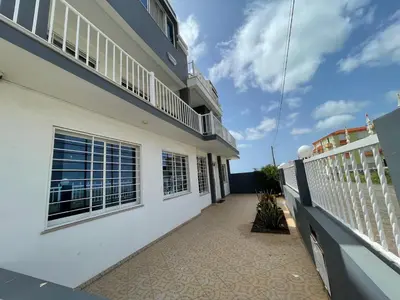 a balcony of a white building with a fence at Villa RESIDENCIAL EUNICE in Praia