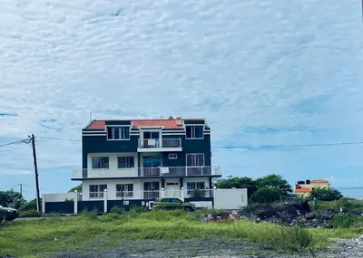 a blue house with a car parked in front of it at Villa RESIDENCIAL EUNICE in Praia