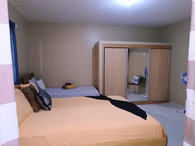 a bedroom with a large bed and a mirror at Pensão Dona Fica in Tarrafal