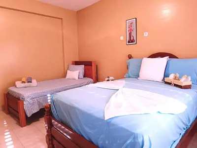 a bedroom with two beds with stuffed animals on them at Pensão Dona Fica in Tarrafal