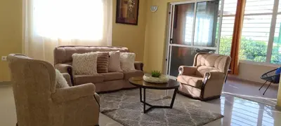 a living room with two chairs and a table at Zeyden Place Apt in Praia