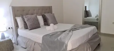 a bedroom with a bed with pillows and a mirror at Zeyden Place Apt in Praia